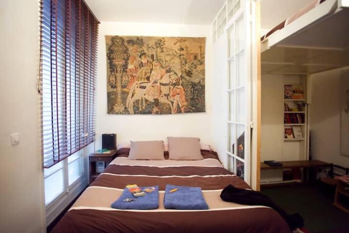 sypialnia z 2 łóżkami i obrazem na ścianie w obiekcie Bien situe w Paryżu