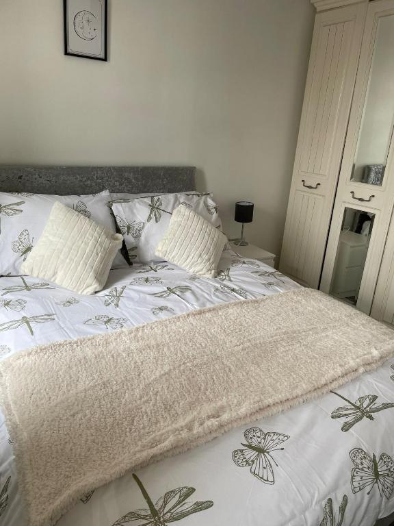 1 cama con edredón blanco y almohadas en Homely property close to Princess Royal hospital and Apley Wood en Wellington