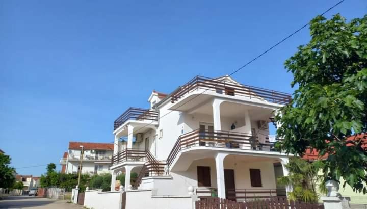 a white building with stairs on the side of it at Apartman-Kuzminski-Kraje14 in Vodice