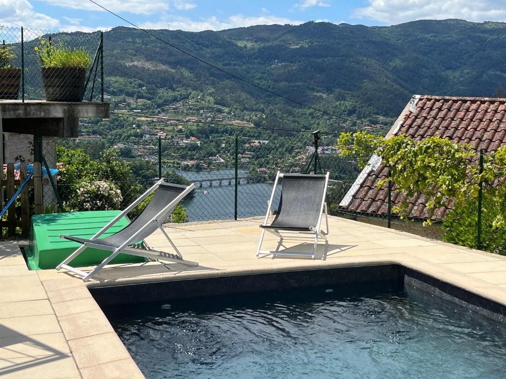 2 sillas sentadas junto a una piscina en Casa da Lage - Piscina privada - Vistas rio, en Gerês