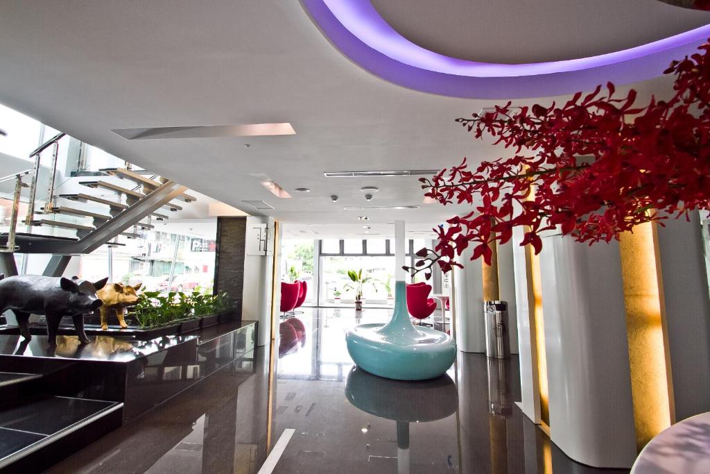 a lobby with a vase on a table and red flowers at HOTEL HI - Xinmin in Chiayi City
