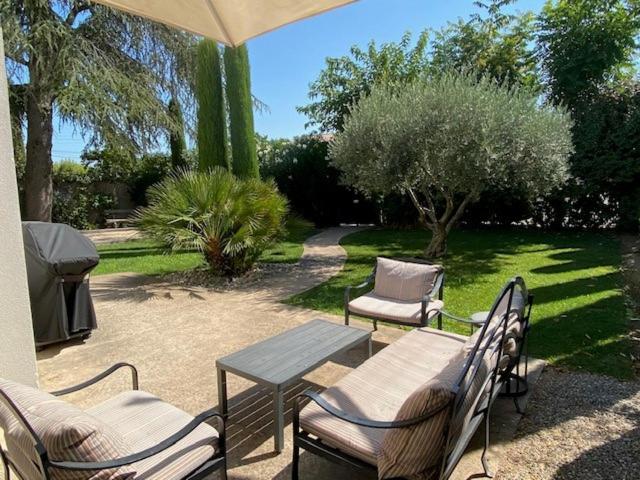un patio avec une table, des chaises et un parasol dans l'établissement La maison de Suzy, à Saint-Rémy-de-Provence