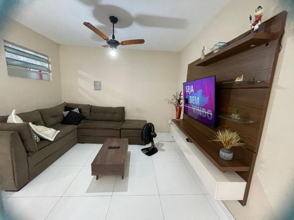 sala de estar con sofá y TV en Casa Azul Triplex en Cabo Frío