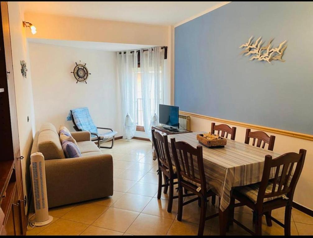 a living room with a table and a couch at Lovely Marinella in Marinella di Sarzana