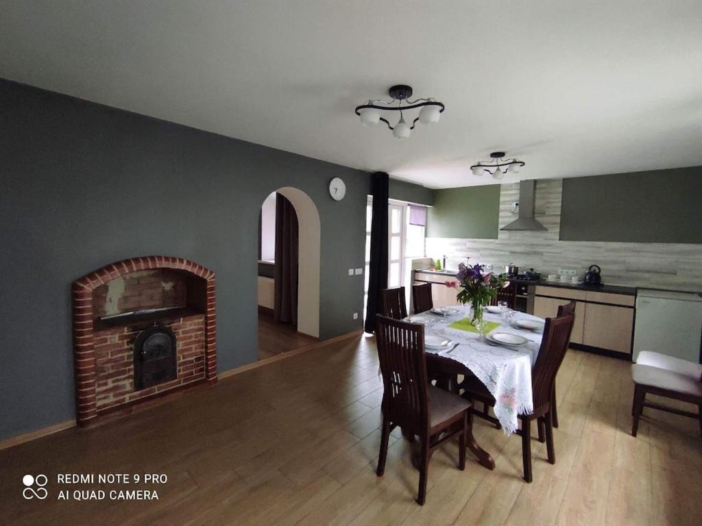 uma cozinha e sala de jantar com uma mesa e uma lareira em Casa Maria 