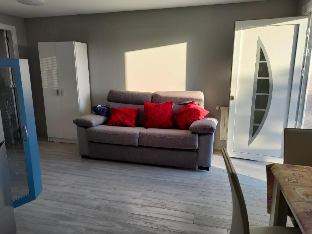 un soggiorno con divano e cuscini rossi di Apartamento Loft A Estivada Bajo a Rosal