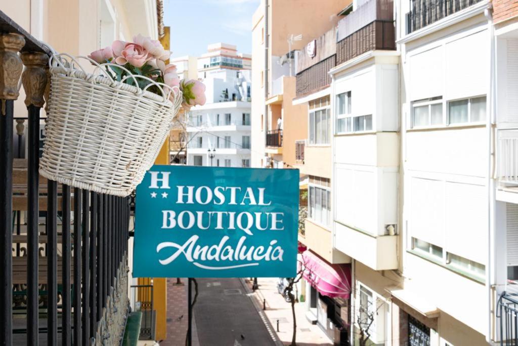 a sign hanging from a balcony with a basket of flowers at Hotel Boutique Andalucia in Fuengirola