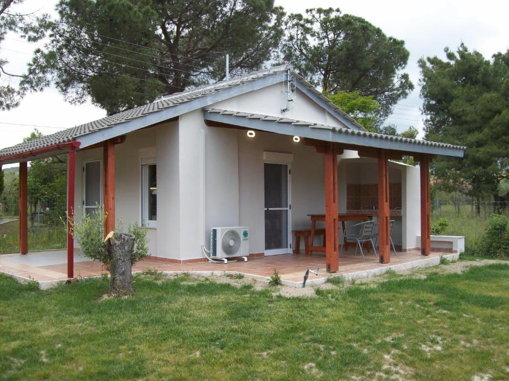 una piccola casa bianca con terrazza e tavolo di ΑΚ Studios Spitaki 3 a Ormos Panagias