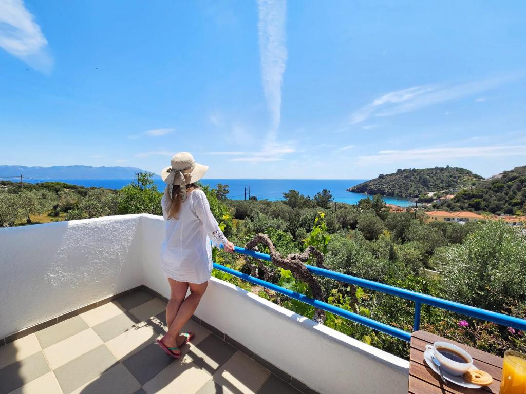 a woman standing on a balcony looking out at the ocean at Galini Studios in Marathokampos