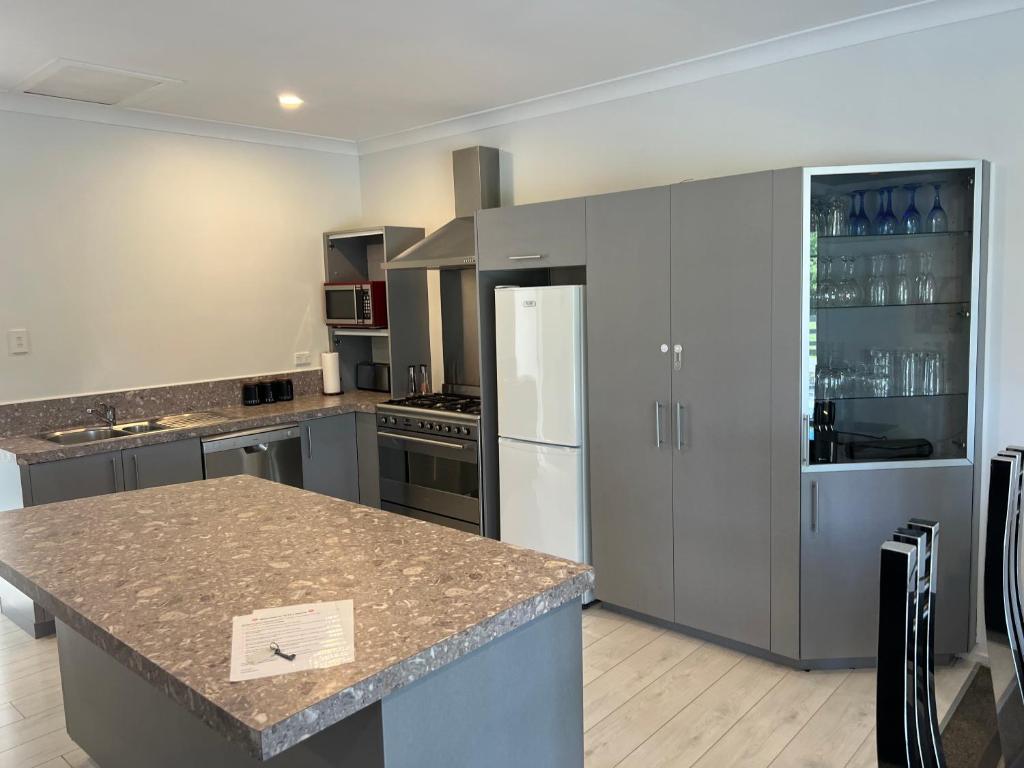 a kitchen with stainless steel appliances and a counter top at A Cut Above Lodge - The Gateway to the Bay of Islands in Kerikeri