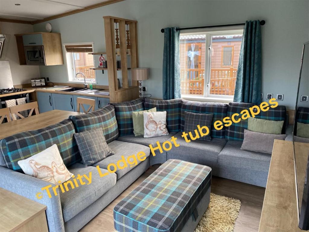 a living room with a couch and a kitchen at Trinity lodge hot tub escapes at Tattershall lakes in Tattershall