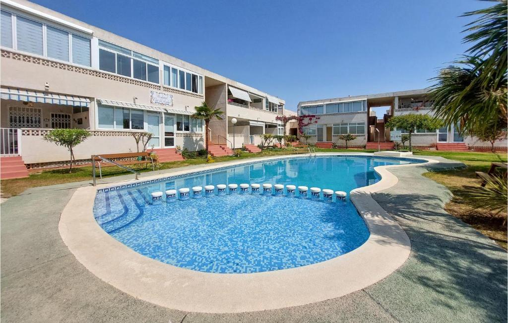 a swimming pool in front of a building at Cozy Apartment In Vinaroz With Kitchen in Vinarós