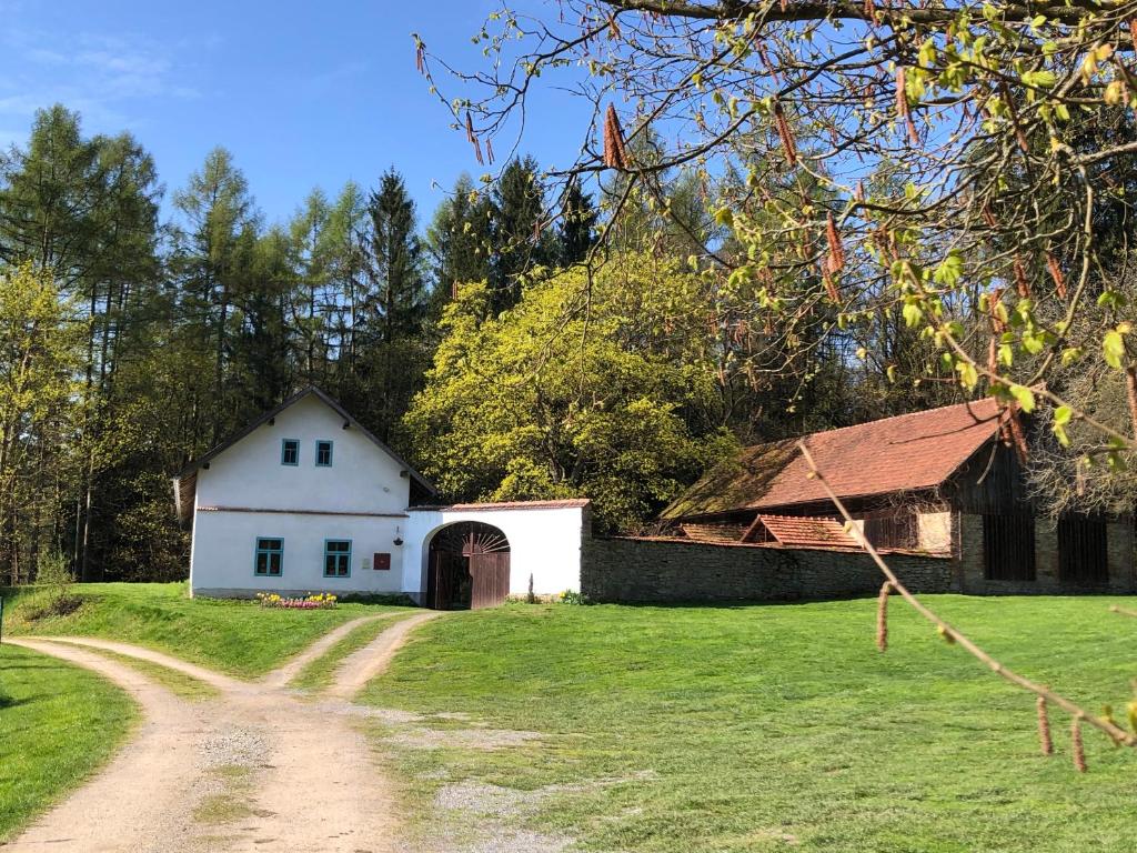 a white house with a barn and a dirt road at Samota Křemen 