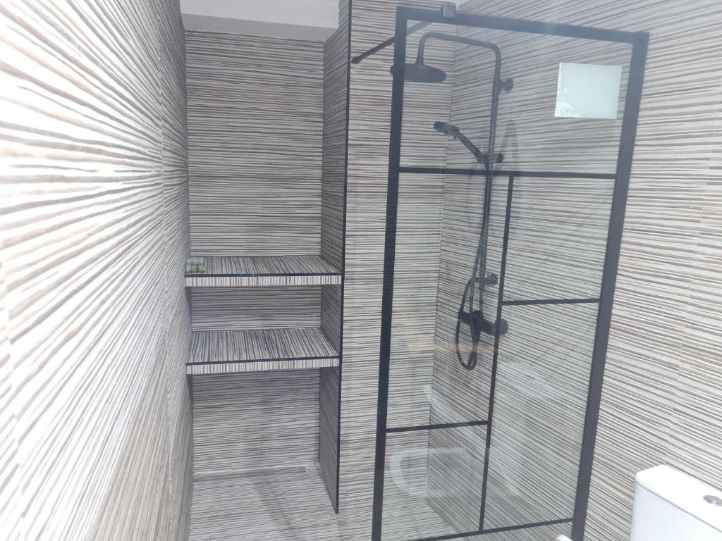 een badkamer met een douche en een glazen plank bij CENTRUM in Alicante