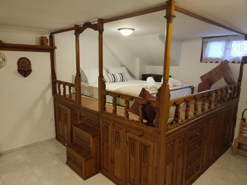 una camera con letto a baldacchino in legno di Captain's Mermaid Houses, Karpathos a Karpathos