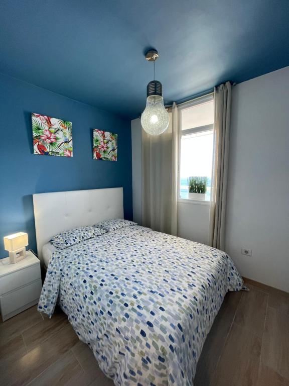 a blue bedroom with a bed and a window at Blue relax Tabaiba in Tabaiba