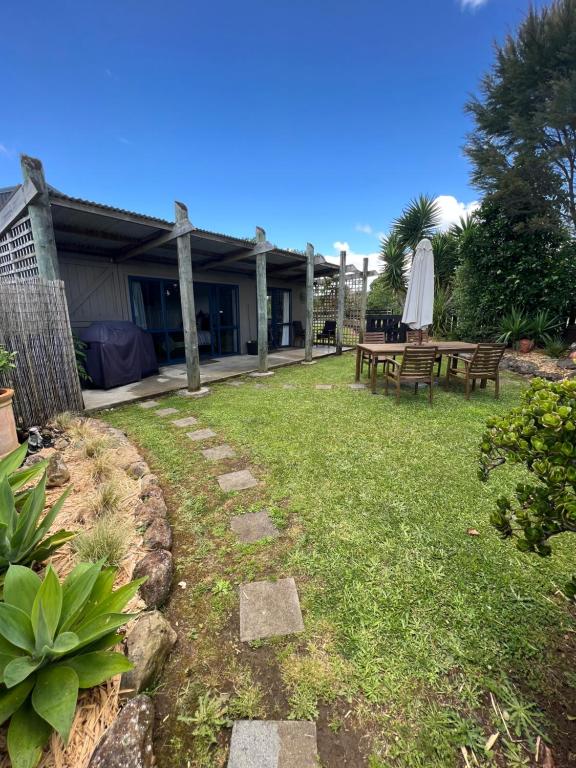 a backyard with a picnic table and a umbrella at A Cut Above Lodge - The Gateway to the Bay of Islands in Kerikeri