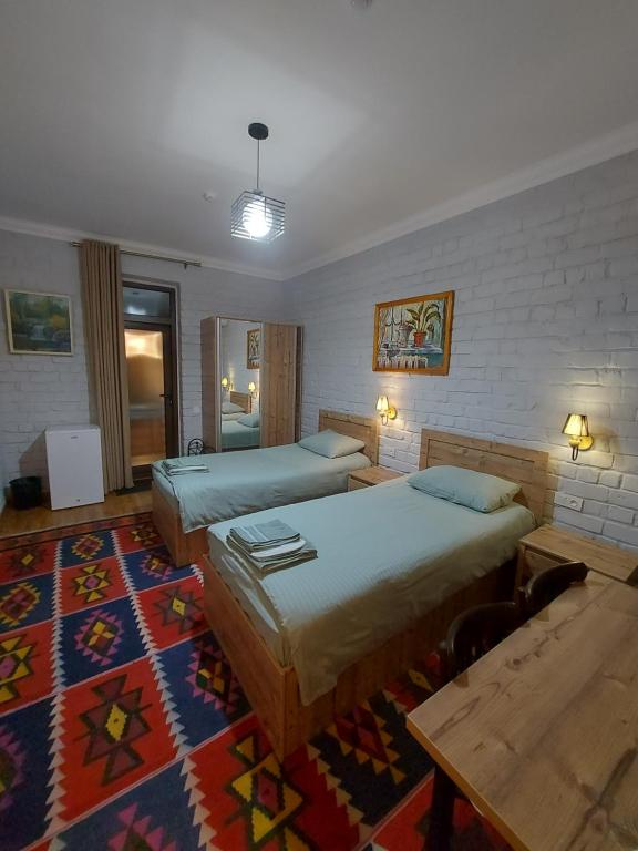 Habitación de hotel con 2 camas y alfombra en MUSAVVIR, en Samarkand