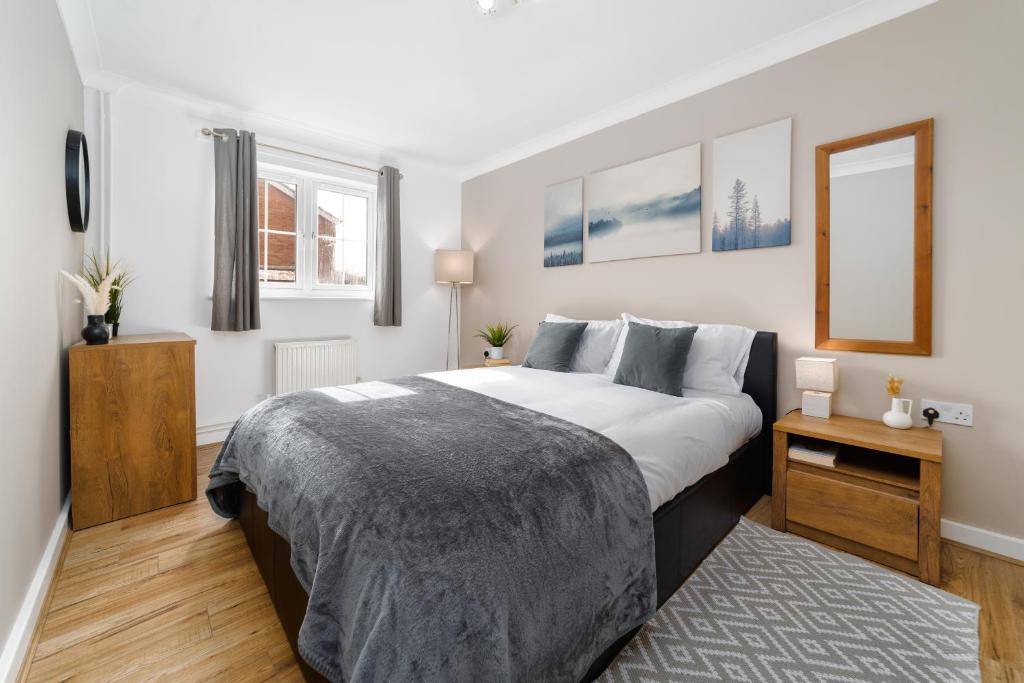 um quarto com uma cama grande e um espelho em Charming 2BR Ground Floor Flat in Sholing, 11 Mins from City Centre - Recently Set Up with Love em Southampton