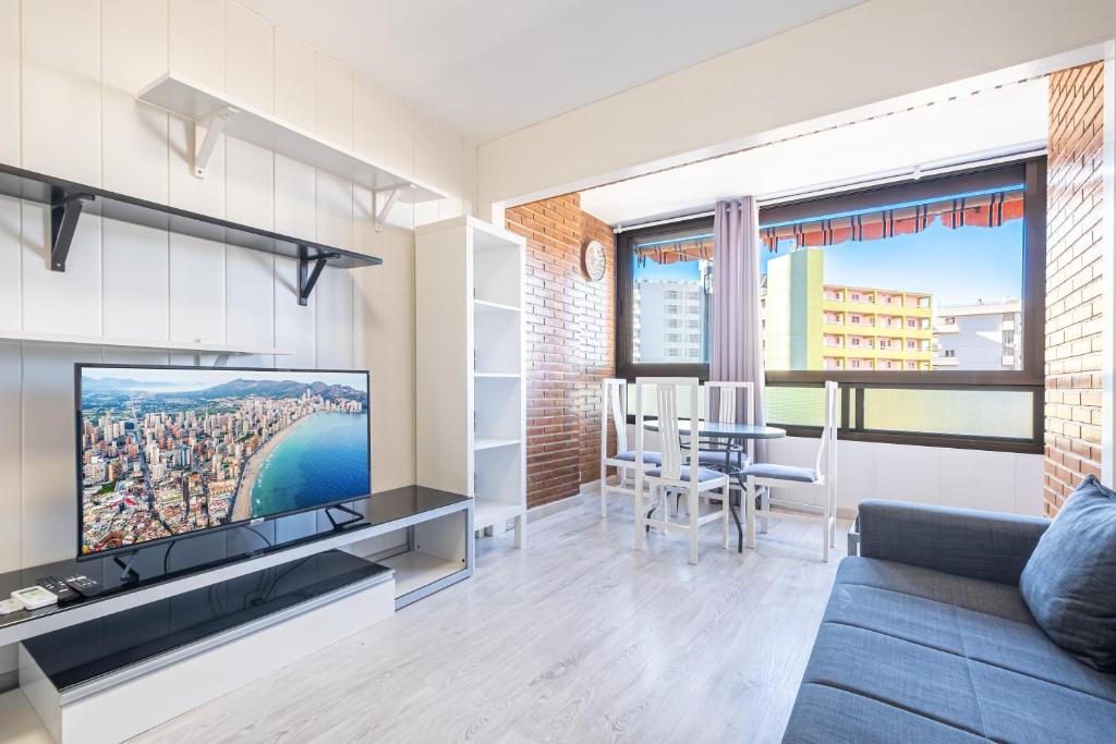 un soggiorno con divano, TV e tavolo di Auge 4-A Apartment Levante Beach a Benidorm