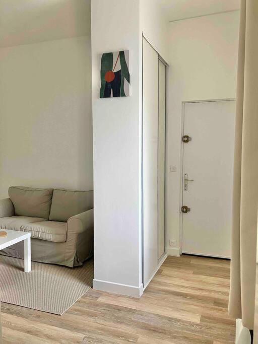 - un salon avec un canapé, une table et une porte dans l'établissement Les Capucins.Appartement élégant,Vue sur le jardin, à Brest