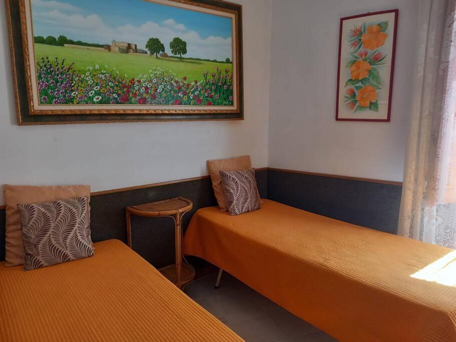 a room with two beds and a painting on the wall at La Casa Degli Artisti in Veglie