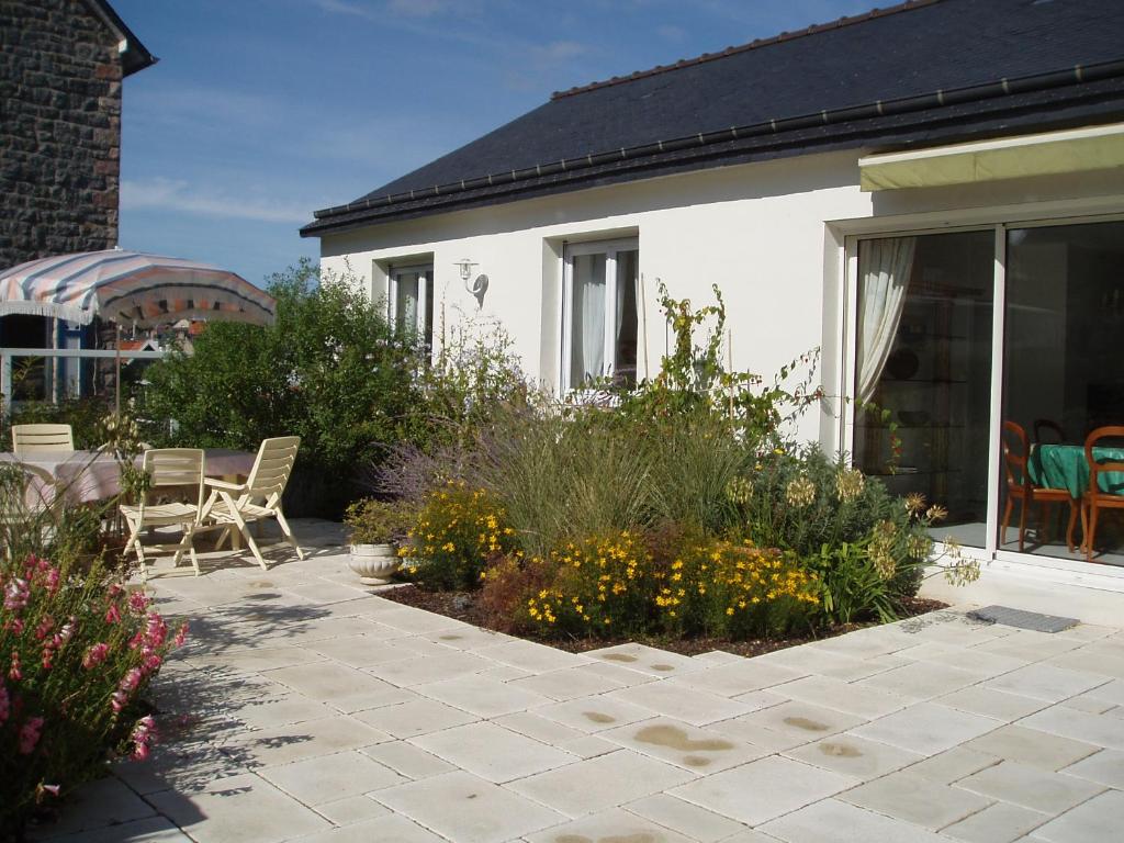 een patio met stoelen en bloemen voor een huis bij Maison des Agapanthes PLENEUF VAL ANDRE in Pléneuf-Val-André