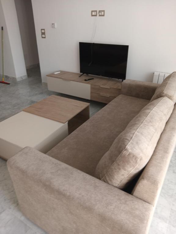 - un salon avec un canapé et une télévision dans l'établissement Residence de la plage, à Port El-Kantaoui