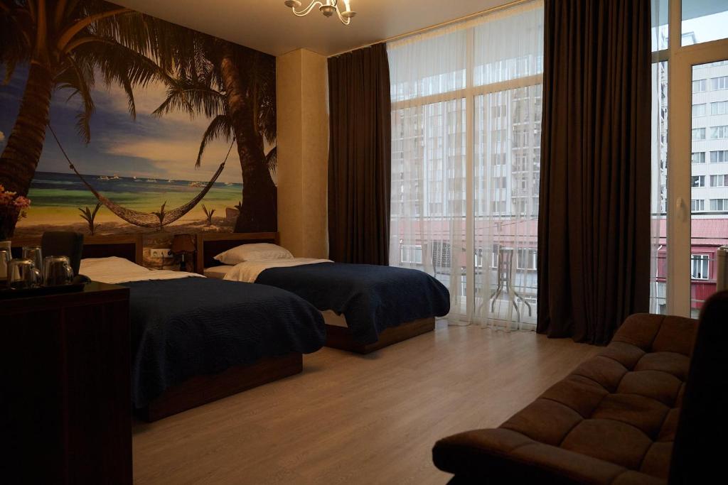 a hotel room with two beds and a large window at HOTEL LORD in Batumi
