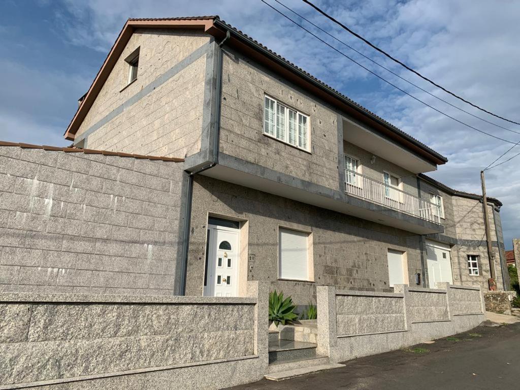 a large brick house with a balcony on top at Casa Tía María in Villanueva de Arosa