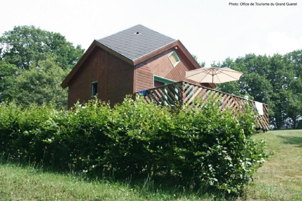 ein kleines Haus mit einem Regenschirm auf einem Feld in der Unterkunft Chalet Park Jouillat 