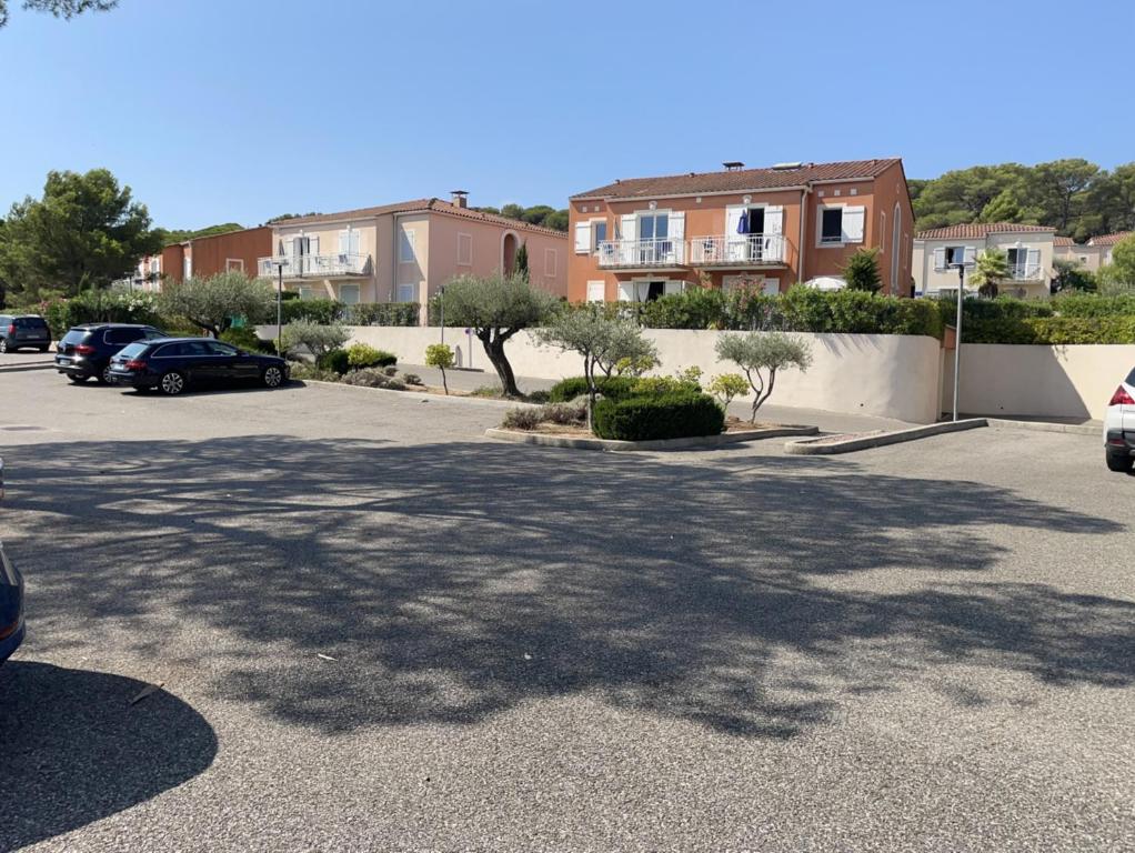 a parking lot with cars parked in front of houses at Superbe appartement 6pers avec piscine et jardin in Fréjus
