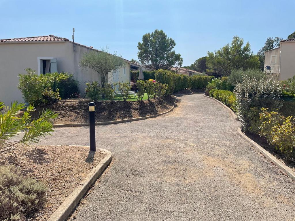 a driveway with a parking meter in a garden at Superbe appartement 6pers avec piscine et jardin in Fréjus