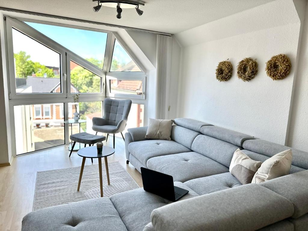 ein Wohnzimmer mit einem Sofa und einem Stuhl in der Unterkunft Apartment über den Dächern Hamelns in Hameln