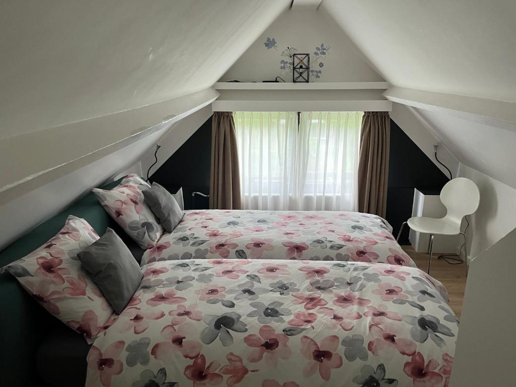 1 Schlafzimmer mit einem Bett mit Blumendecke in der Unterkunft Enjoy Heuvelland in Simpelveld