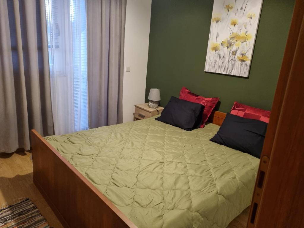 - une chambre avec un grand lit aux murs verts dans l'établissement EMI 1 apartment, à Vir