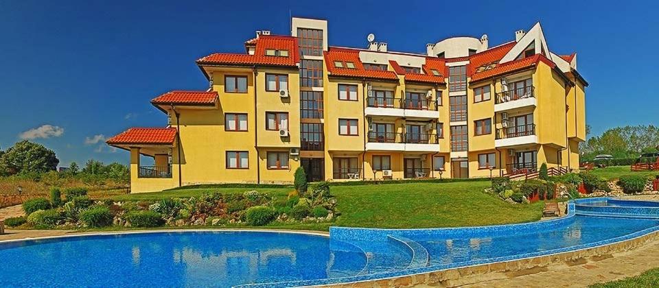 un gran edificio con una piscina frente a él en EGGO APARTMENT - Oasis Beach Apartments Kamchia en Dolen Bliznak