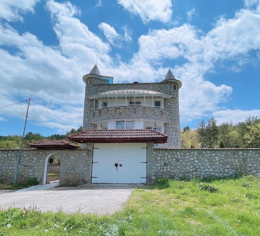 um edifício com uma porta branca e uma parede em Къща за гости Замък Никола em Shtarkelovo Gnezdo