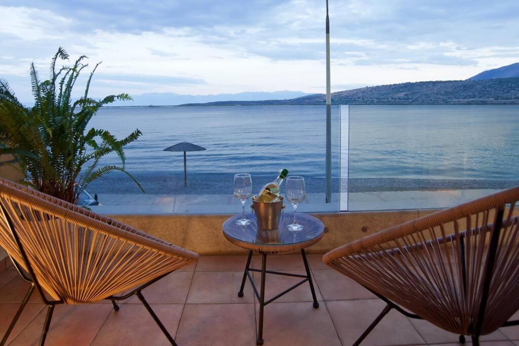 mesa y 2 sillas con vistas al agua en Seagull Luxury Maisonette, en Itea