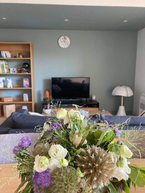 un salon avec un vase de fleurs sur une table dans l'établissement Appartement coeur Saint Remy de Provence, à Saint-Rémy-de-Provence
