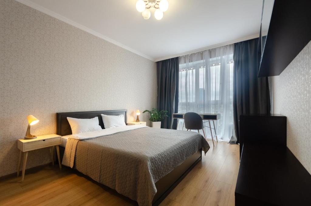 a bedroom with a bed and a desk and a window at 0727 Kvartet cozy apartment nearby with Central Railway Station in Kyiv