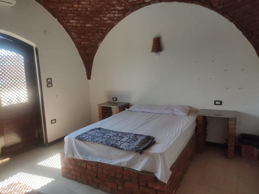 a bedroom with a bed in a brick room at Julia View in Luxor