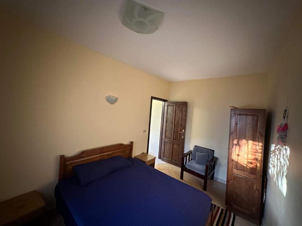 um quarto com uma cama azul e uma cadeira em Turtle house em Dahab