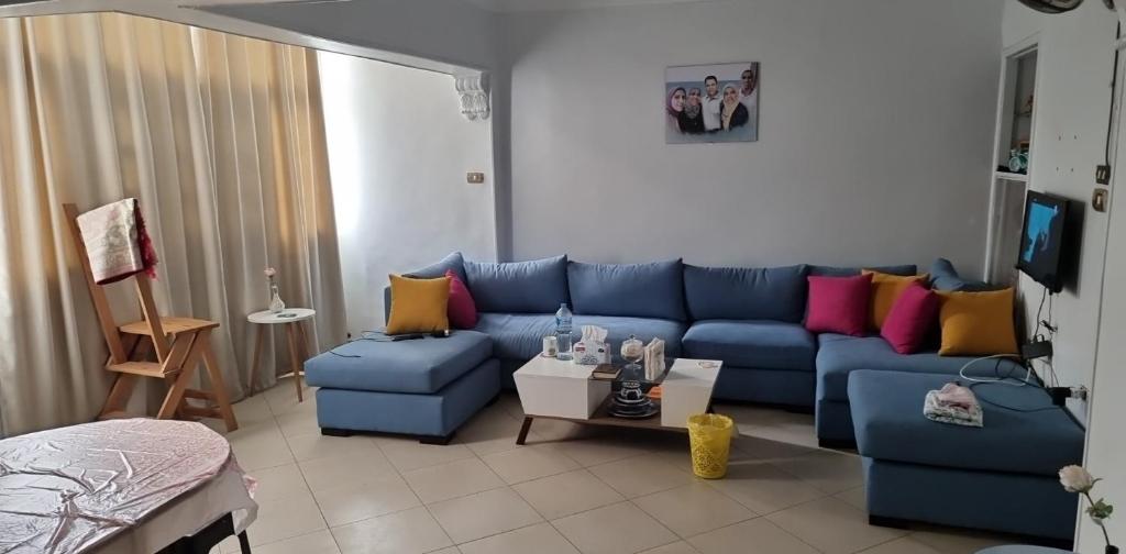 - un salon avec un canapé bleu et des oreillers colorés dans l'établissement "sara accommodation room "no Egyptians "Dormitory room, au Caire
