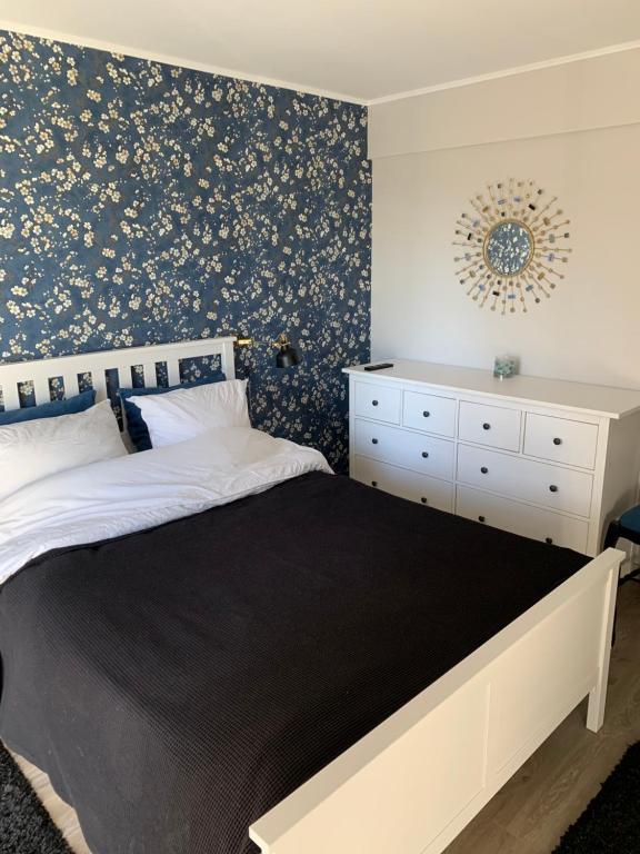 - une chambre avec un lit et un mur orné de papier peint floral dans l'établissement Chambre complètement indépendante !, à Limoges