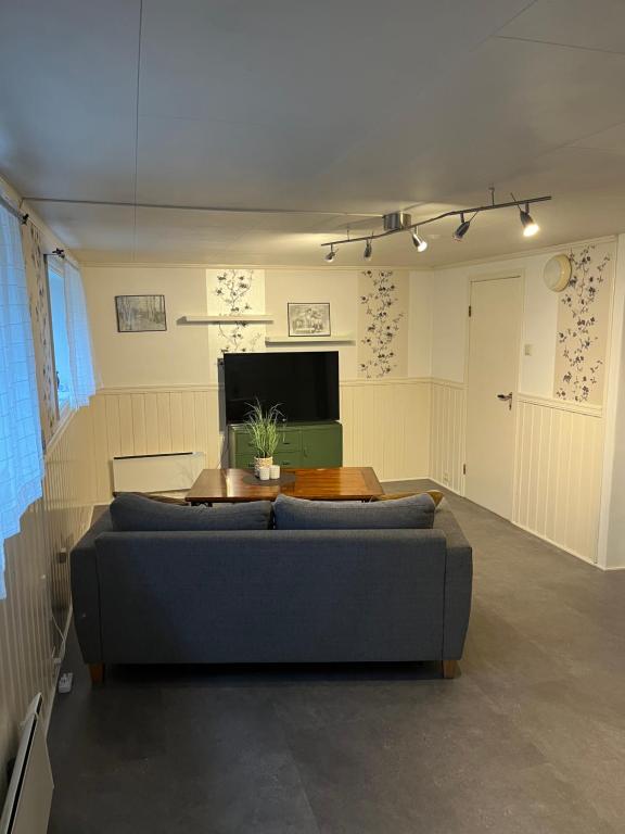 - un salon avec un canapé et une table dans l'établissement Overnatting på Leknes, à Leknes