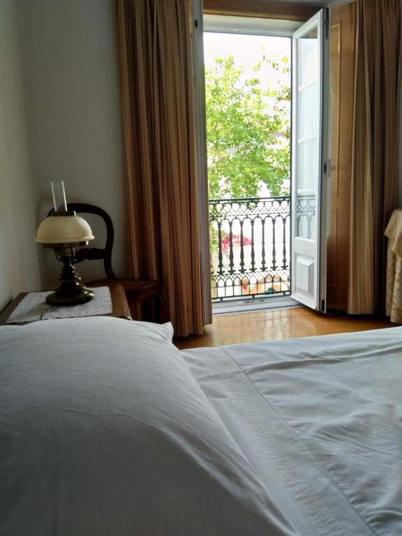 a bedroom with a bed and a door to a balcony at CASA DO LARGO in Atouguia da Baleia