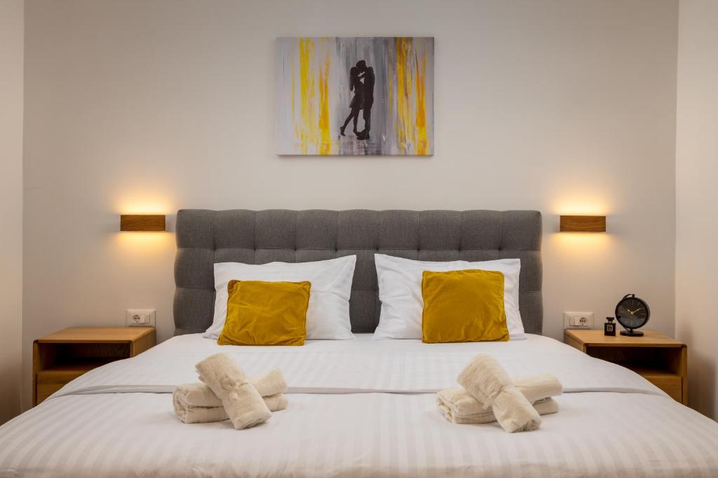 a bedroom with a large bed with yellow pillows at The Box in Split