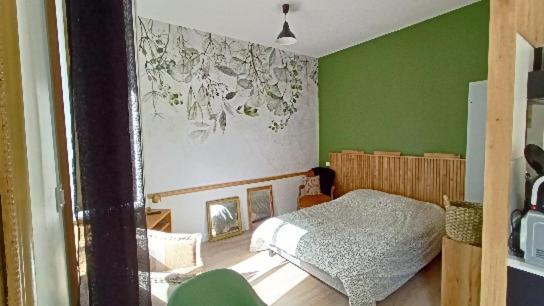 ein Schlafzimmer mit grünen Wänden und einem Bett in der Unterkunft Le Raffiné in Millau