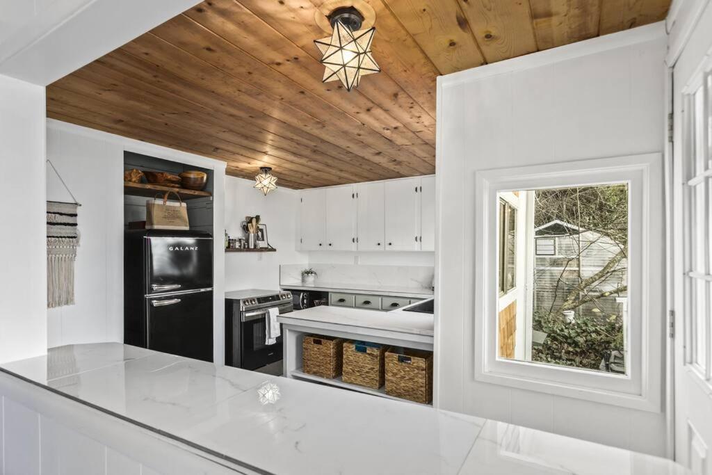 uma cozinha com paredes brancas e um tecto de madeira em Cedar and Sage em Tacoma